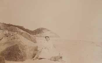 Mrs. Jim Scott and dog seated by rock at east end of Singing Beach, Manchester Photograph