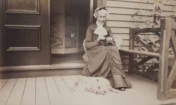 Betsy Wilder seated on piazza, with dog at her feet Photograph