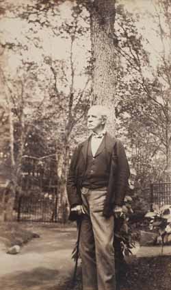 Robert W. Hooper standing outdoors with tree Photograph